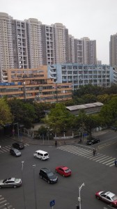 street with cars in the foreground, old and new highrises in the background